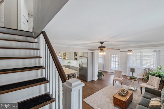 living area featuring stairway, dark wood finished floors, and crown molding