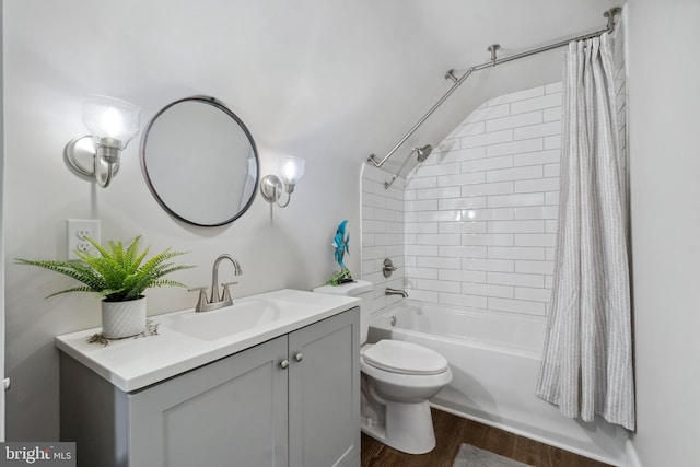 bathroom featuring toilet, shower / tub combo, wood finished floors, and vanity