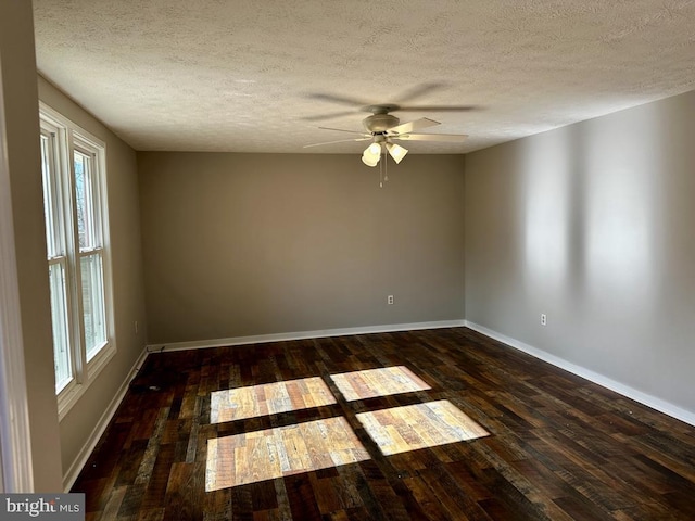 unfurnished room featuring dark wood-type flooring, ceiling fan, a textured ceiling, and a wealth of natural light