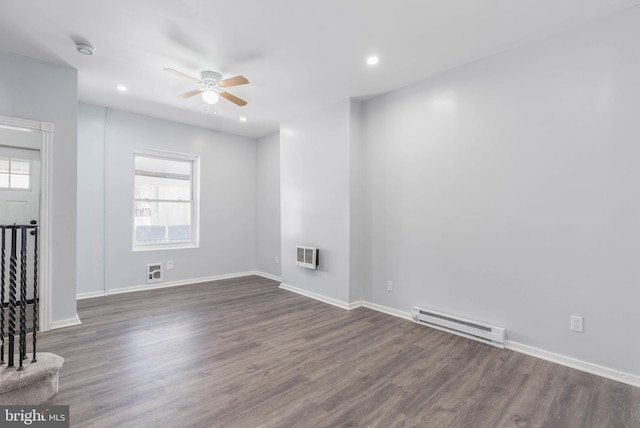 empty room with ceiling fan, a baseboard radiator, dark hardwood / wood-style floors, and heating unit