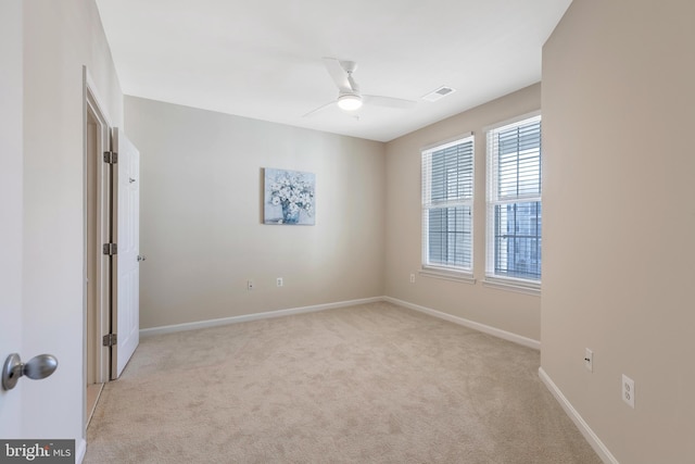 empty room featuring ceiling fan and light carpet