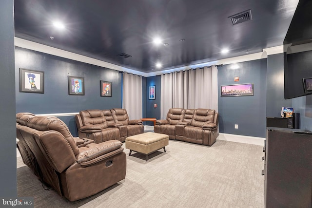 carpeted home theater featuring crown molding