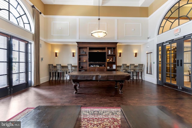 interior space with a high ceiling, dark hardwood / wood-style floors, pool table, and french doors