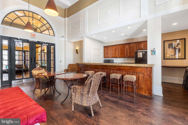 dining room with french doors, a towering ceiling, and dark hardwood / wood-style floors