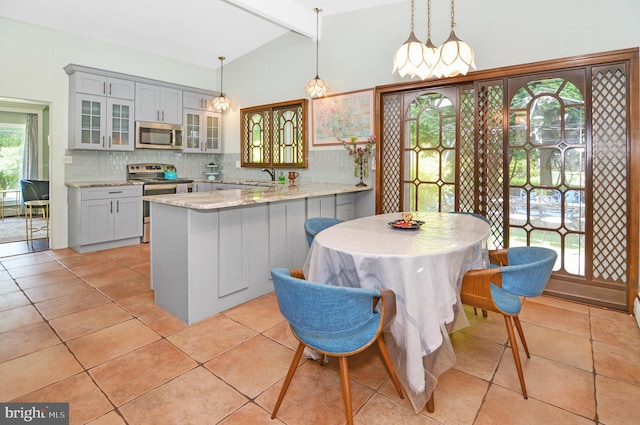 kitchen featuring appliances with stainless steel finishes, decorative light fixtures, glass insert cabinets, and decorative backsplash