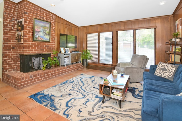 living area with wood walls, plenty of natural light, a fireplace, and tile patterned floors