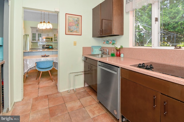 kitchen with light tile patterned floors, hanging light fixtures, stainless steel appliances, light countertops, and a sink