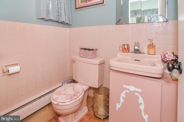 half bathroom with toilet, a wainscoted wall, tile walls, and vanity