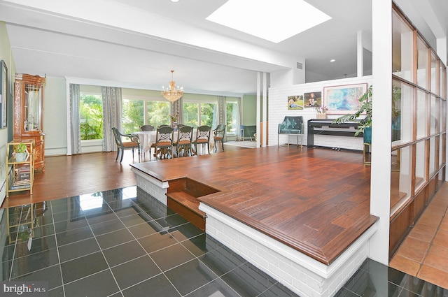 dining space featuring a chandelier, dark tile patterned flooring, plenty of natural light, and baseboard heating