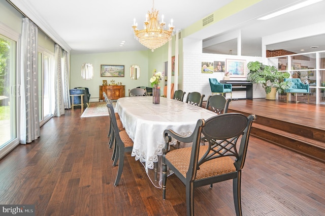 dining space featuring dark wood-style flooring, visible vents, and a notable chandelier