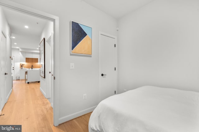 bedroom with sink and light wood-type flooring