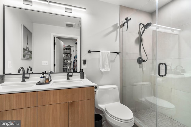 bathroom featuring vanity, a shower with shower door, and toilet