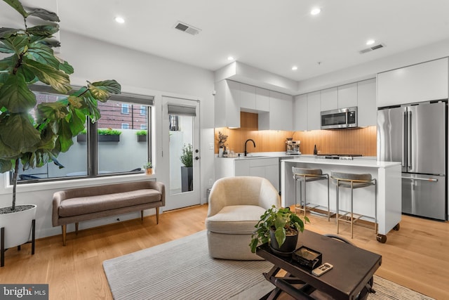 living room with sink and light hardwood / wood-style flooring