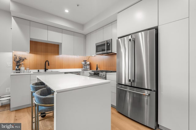 kitchen with white cabinets, a center island, sink, and premium appliances