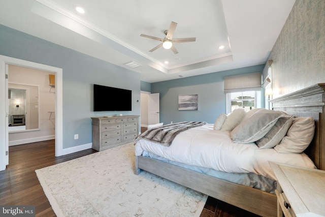 bedroom with crown molding, dark hardwood / wood-style flooring, and a raised ceiling