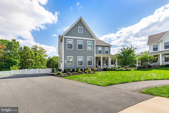 view of front of house featuring covered porch and a front lawn