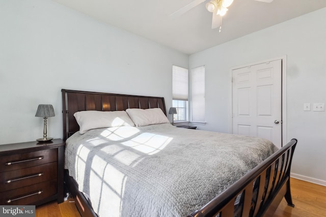 bedroom featuring light wood finished floors, a ceiling fan, and baseboards