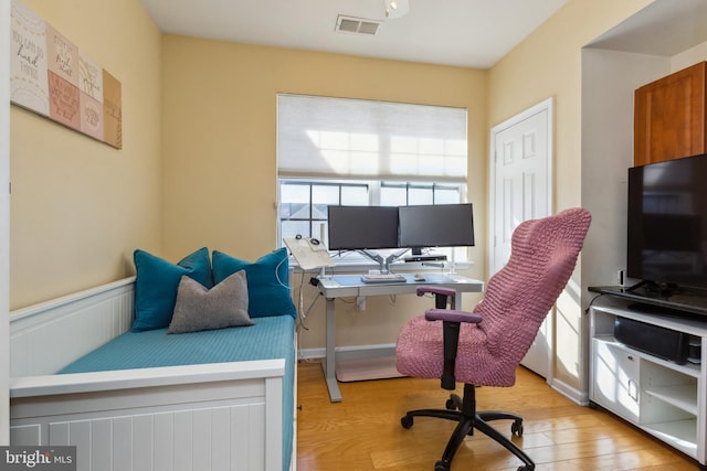 office area with wainscoting, visible vents, and light wood finished floors