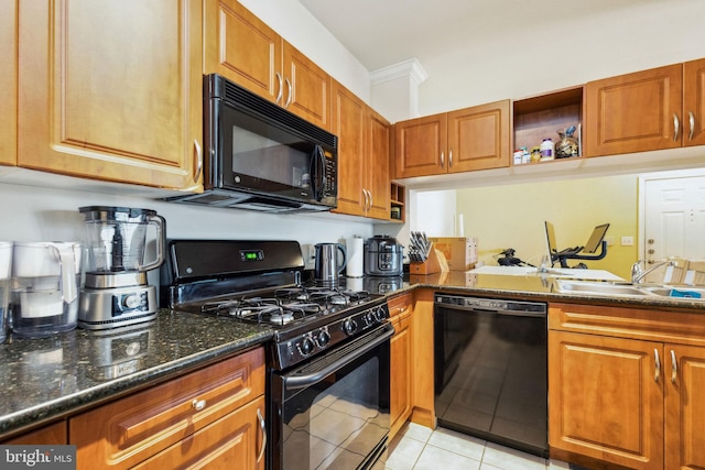 kitchen with brown cabinets, open shelves, a sink, dark stone counters, and black appliances