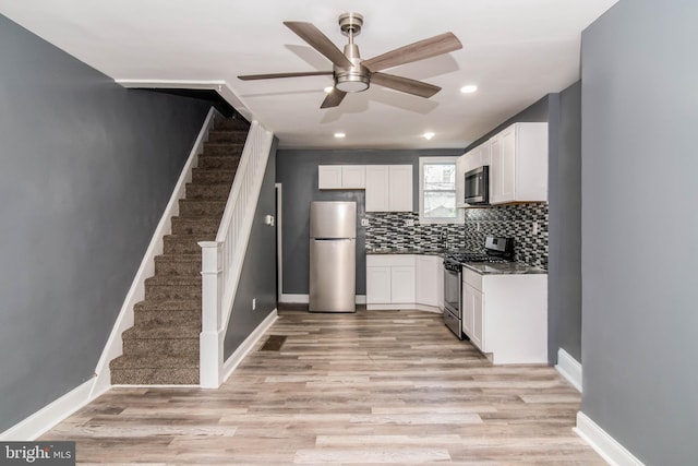 kitchen featuring white cabinetry, light wood-type flooring, tasteful backsplash, and appliances with stainless steel finishes