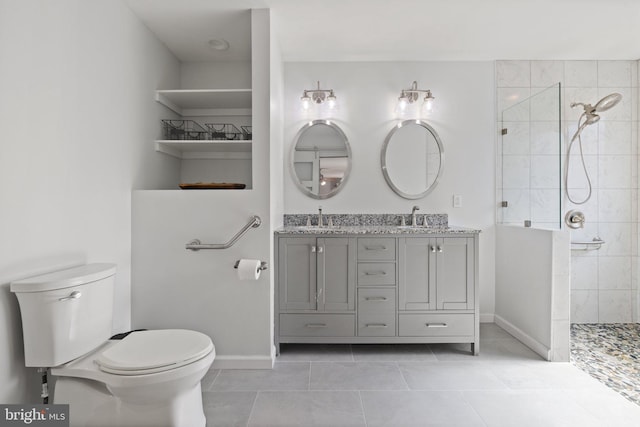 bathroom featuring double vanity, toilet, a walk in shower, and a sink