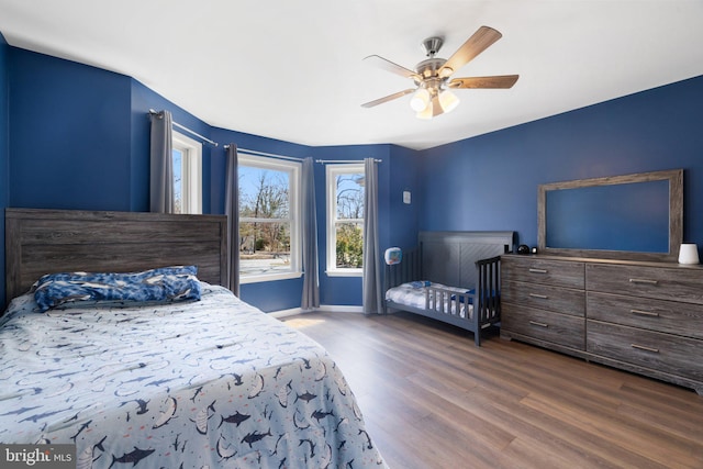 bedroom with baseboards, wood finished floors, and a ceiling fan