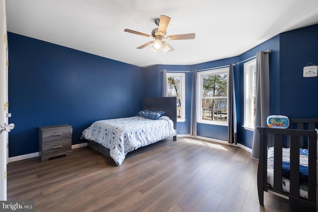 bedroom with a ceiling fan, wood finished floors, and baseboards