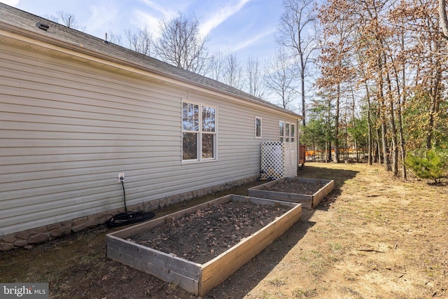 view of side of home featuring a garden