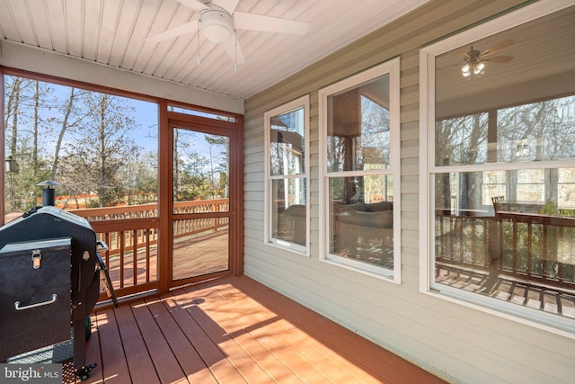 sunroom featuring a healthy amount of sunlight, wooden ceiling, and a ceiling fan