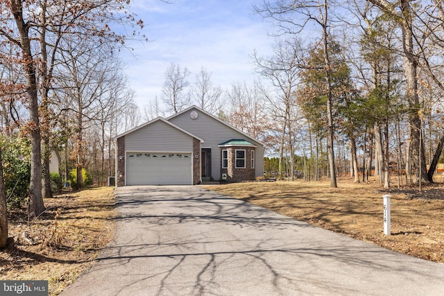 view of front of property with aphalt driveway, an attached garage, and brick siding