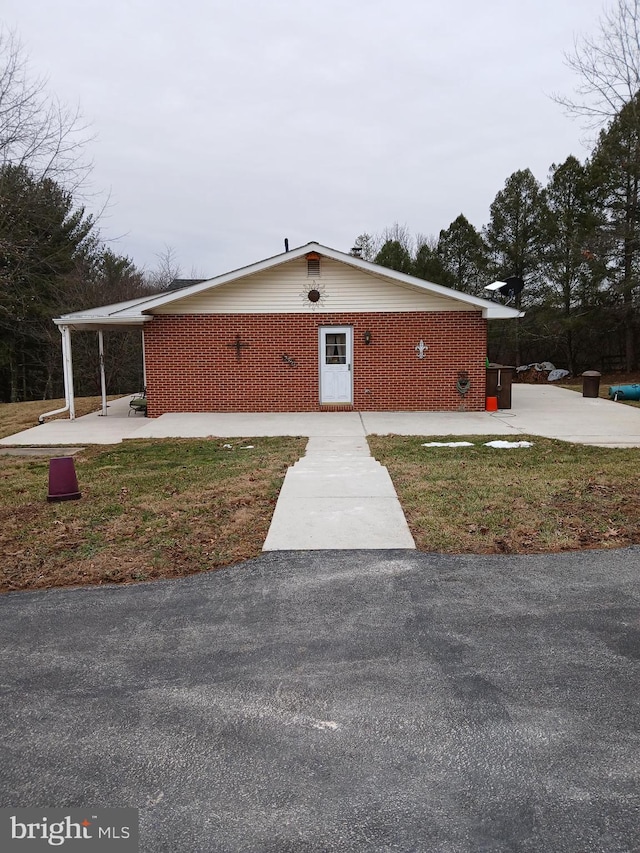 view of front facade with a front yard and brick siding