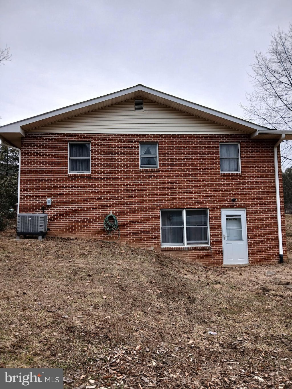 rear view of property with brick siding and central AC unit