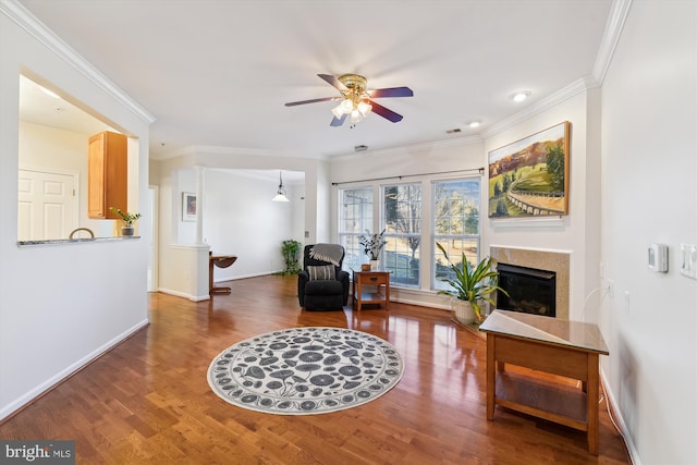 sitting room featuring ceiling fan, ornamental molding, and wood-type flooring