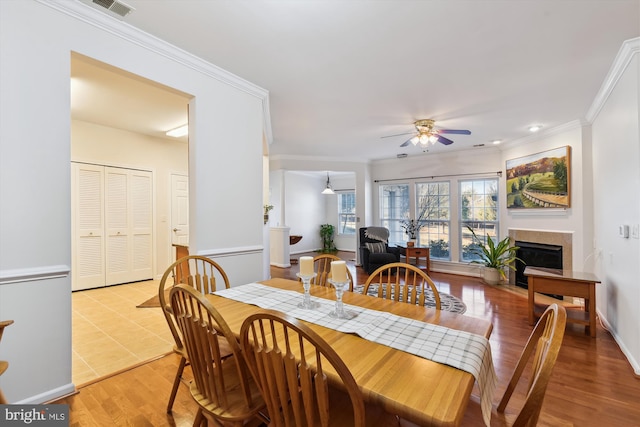 dining room with light hardwood / wood-style flooring, ornamental molding, and ceiling fan