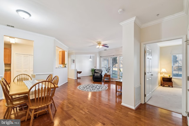 dining space with hardwood / wood-style flooring, ornamental molding, and ceiling fan