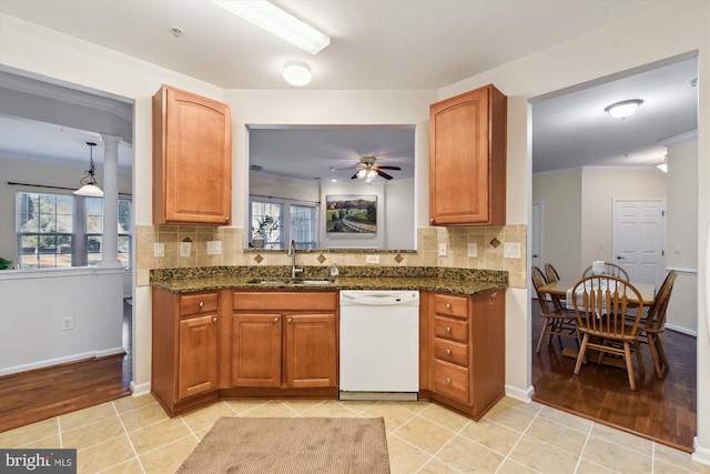 kitchen with light tile patterned flooring, sink, crown molding, and white dishwasher