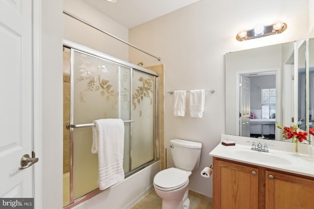 full bathroom featuring vanity, tile patterned floors, shower / bath combination with glass door, and toilet