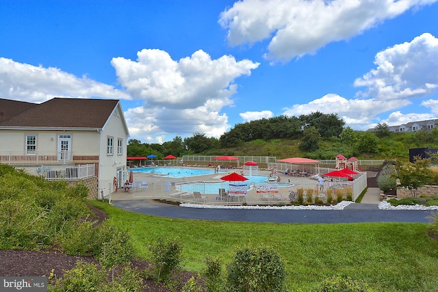 view of pool featuring a patio and a yard