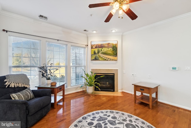 living room with ceiling fan, ornamental molding, and wood-type flooring