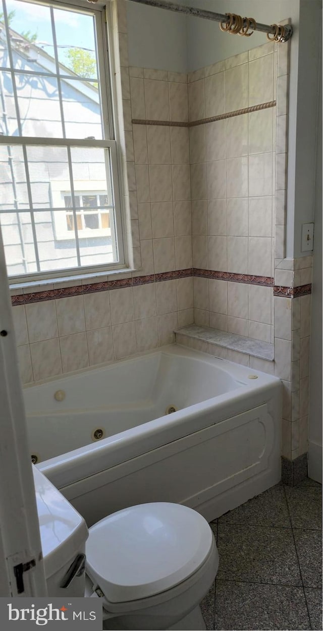 bathroom with tile walls and toilet