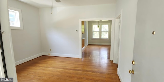 spare room with ceiling fan and light wood-type flooring