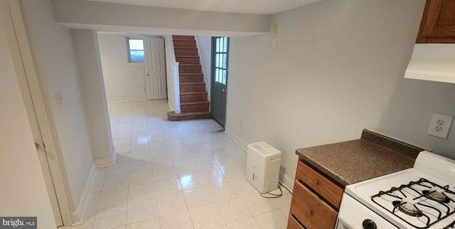 kitchen featuring white range with gas stovetop and light tile patterned floors