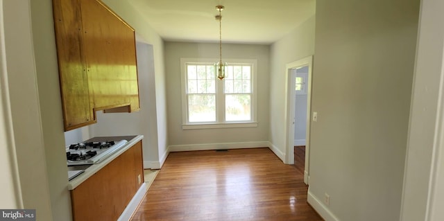 kitchen with light hardwood / wood-style flooring, pendant lighting, and white gas cooktop