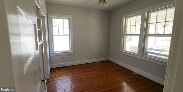 empty room featuring dark wood-type flooring and ceiling fan