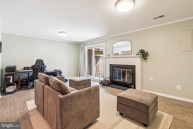 living room with visible vents, baseboards, a fireplace with flush hearth, ornamental molding, and wood tiled floor