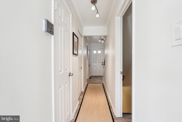 hallway featuring rail lighting and baseboards