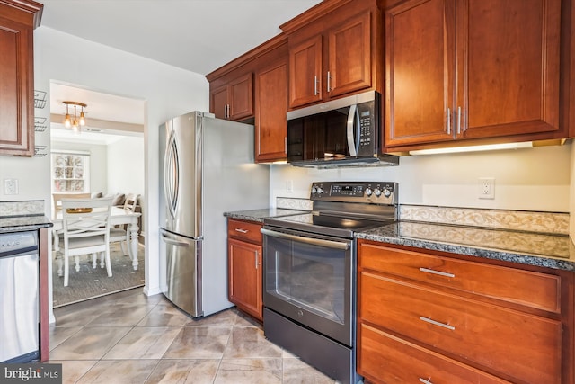 kitchen with stainless steel appliances, dark stone countertops, and light tile patterned flooring