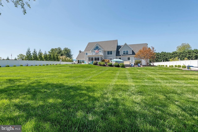 view of front of home with a front lawn and a balcony