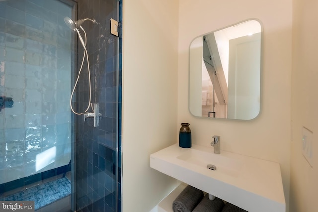 bathroom with tiled shower and sink