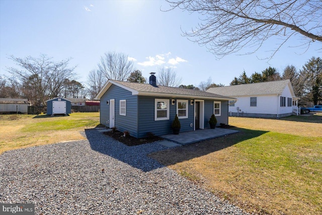 single story home with a patio, a storage unit, and a front lawn